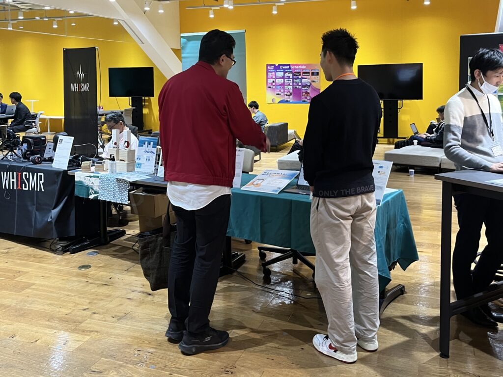 イベントブースにて来訪者の方と話をしている様子